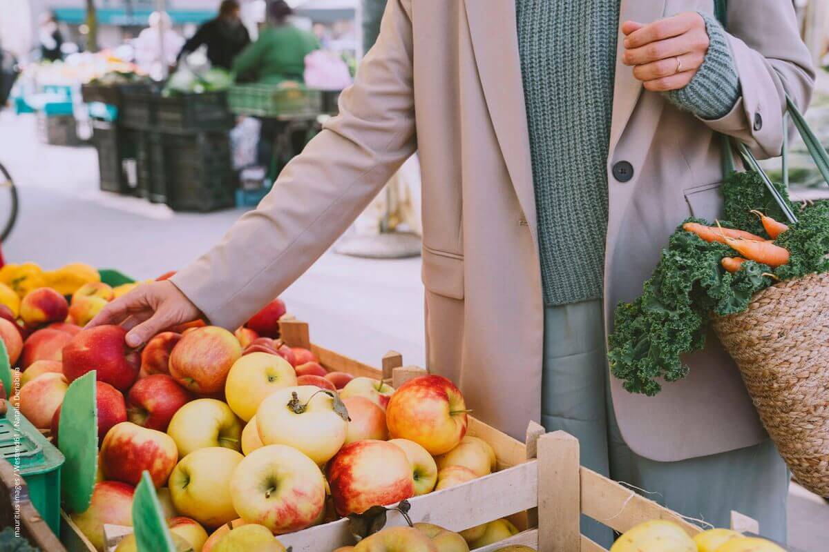 Frau kauft Obst und Gemüse auf einem Markt ein. Bei Nierenkranken sollten bestimmte Obstsorten bevorzugt werden.