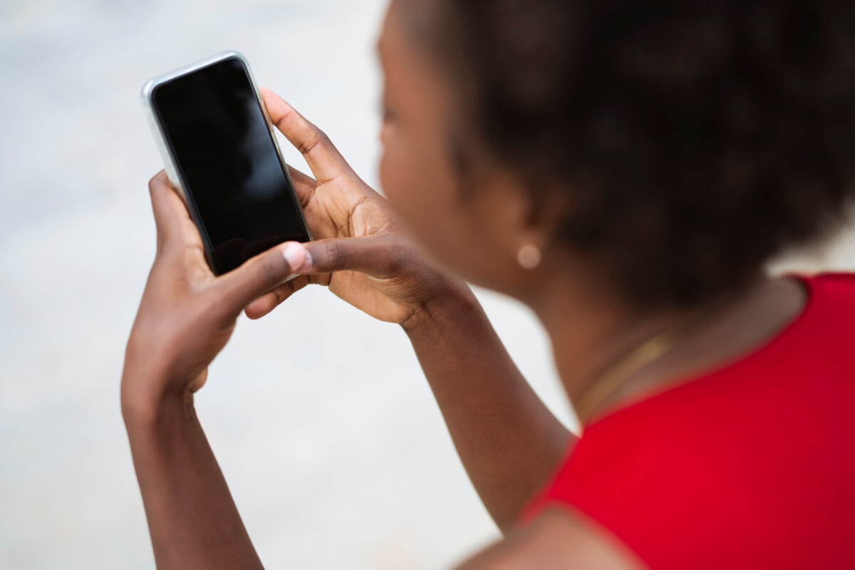 Eine Frau im roten Kleid bedient ein Smartphone