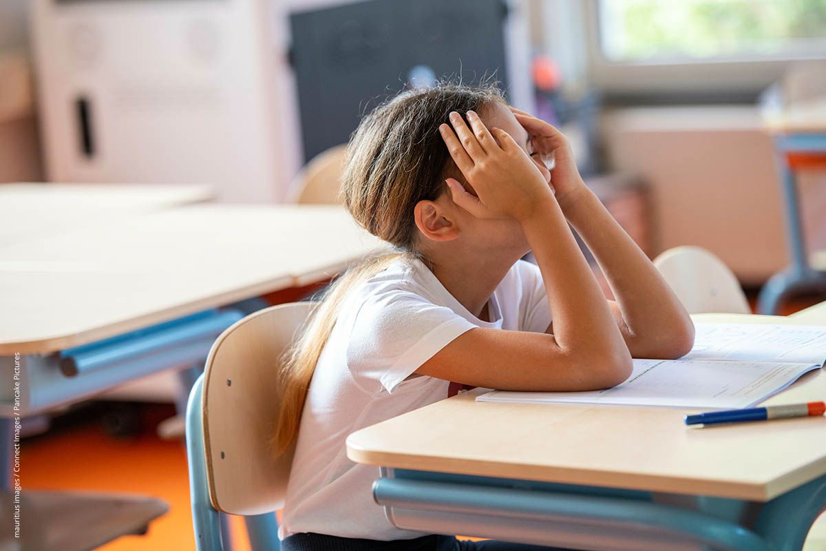 Mädchen sitzt in der Schule und hat Probleme, sich zu konzentrieren.